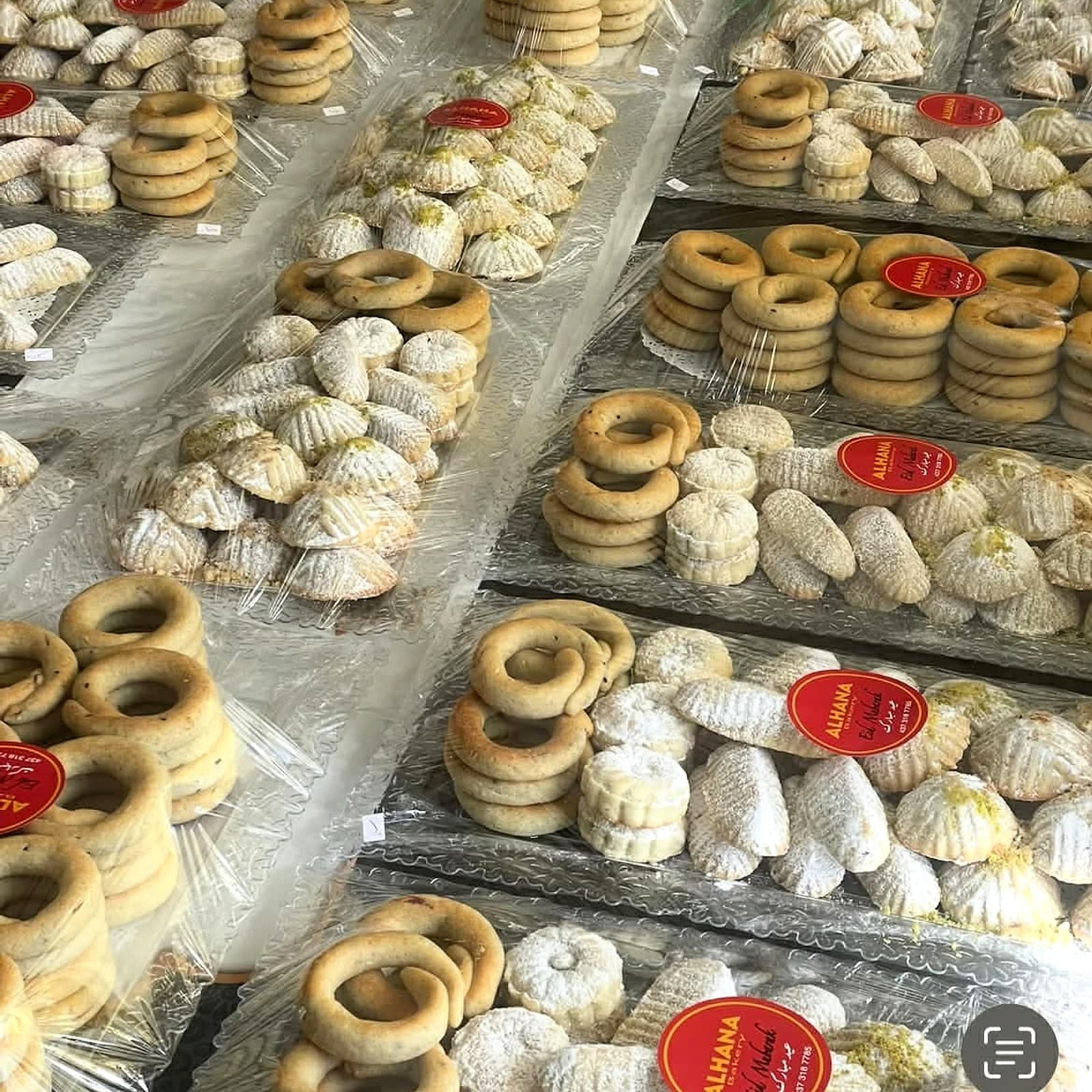 Trays of Alhana cookies — maamoul, kaak, and assorted varieties — packaged with the Alhana red seal
