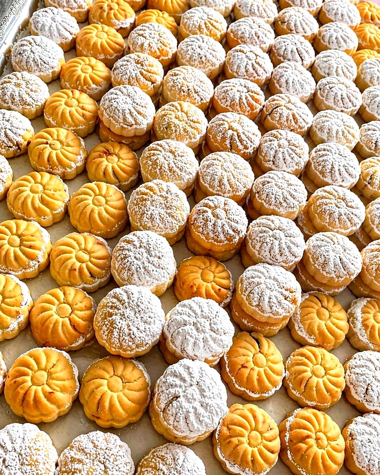 A tray of Alhana date maamoul, golden and powdered-sugar-topped